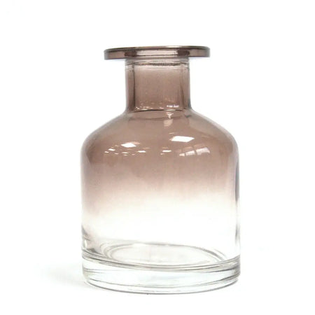 A sleek apothecary style reed diffuser bottle in charcoal glass with a gold finish rim and clear base for bamboo reeds