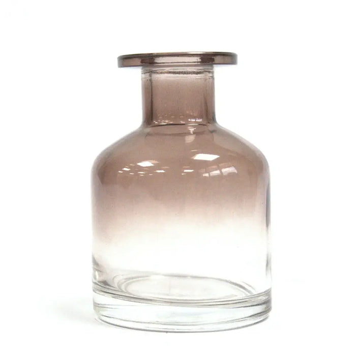 A sleek apothecary style reed diffuser bottle in charcoal glass with a gold finish rim and clear base for bamboo reeds