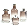 Set of four apothecary style bamboo reed diffuser bottles in gradient brown glass with silver finish bottle stopper caps