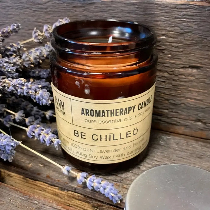 A brown glass jar soy wax aromatherapy candle labeled be chilled with lavender and ferns scent