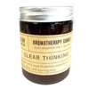 A dark amber glass jar with silver lid and beige label containing a soy wax aromatherapy candle for clear thinking