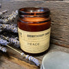 An amber glass jar aromatherapy candle labeled peace with soy wax and lavender essential oils