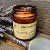 An amber glass jar soy wax aromatherapy candle labeled positive vibes with clary sage and peppermint oils