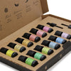 A set of twelve colorful aromatherapy essential oil bottles with black caps in a cardboard gift box starter pack