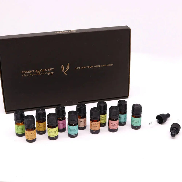 Aromatherapy essential oil set with assorted colored labels and black caps beside a dark brown gift box for summer