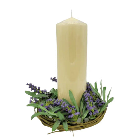 Cream-colored church pillar candle in a woven basket surrounded by artificial lavender sprigs for table decoration