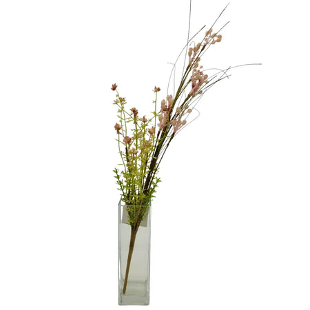 A clear glass vase holding artificial dusky pink berries and green flowering stems in a rectangular shape