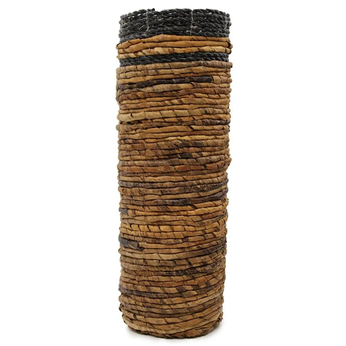 Tall cylindrical woven basket with natural brown and black stripes made from dried plant fibers in a banana leaf set