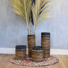 Banana leaf set featuring handwoven cylindrical planters in natural brown and black with textured woven patterns