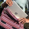 A silver hp laptop inside a pink and white fabric sleeve with a herringbone pattern in the banjar laptop bag design