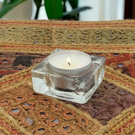 Basic square clear glass tealight holder with a lit white tea light inside glass tealight holder design