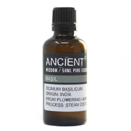 A dark amber glass bottle with a black cap labeled ancient wisdom 50ml pure essential basil essential oil with allergen declarations