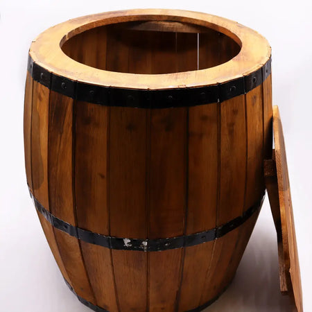 A rustic natural wood beer barrel table with dark metal bands and a matching lid leaning on its side