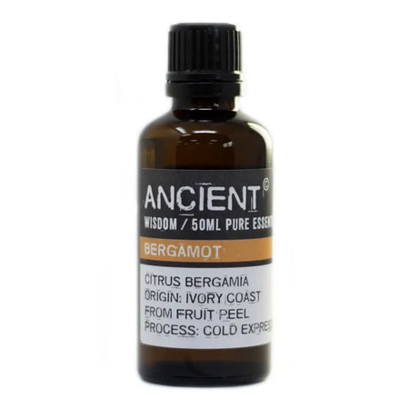 A dark amber glass bottle of bergamot essential oil with a black cap and allergen declarations on the label
