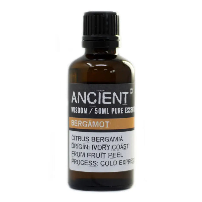 A dark amber glass bottle of bergamot essential oil with a black cap and allergen declarations on the label