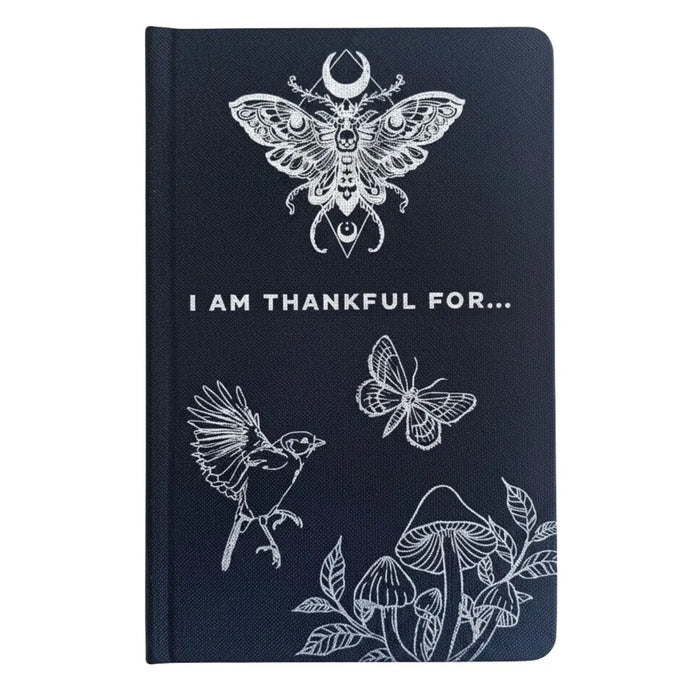 Dark blue textured gratitude journal with white line art of moth bird butterfly mushrooms and i am thankful for text