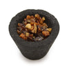 Black textured incense resin cup filled with amber and brown myrrh resin fragments in a box of 12 cups