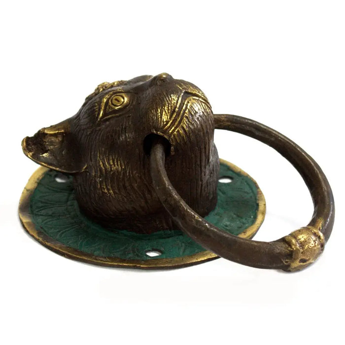 Antique brass door knocker shaped like a cat head with green patina base and gold accented eyes