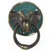 Antique brass door knocker shaped like an elephant head with green patina on a round backplate