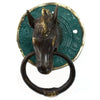 Antique brass door knocker with a bronze horse head and a green and gold circular backplate on a door