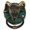 Antique brass door knocker shaped like a ram head with green patina and a circular ring for door use