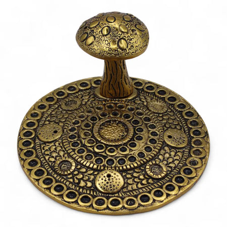Golden brass effect incense holder shaped like a mushroom with intricate circular patterns and a textured stem