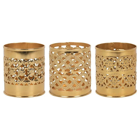 Three brass-finish decorative kasbah tealight holders with intricate cut-out patterns in gold-colored metal