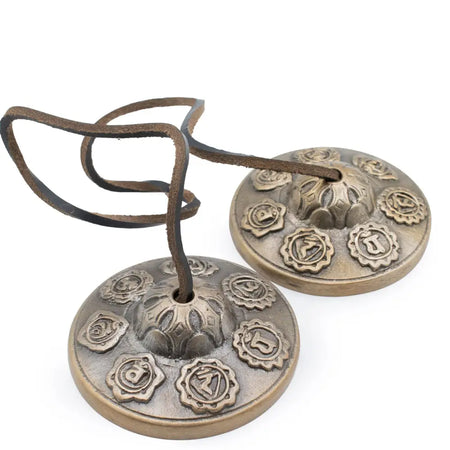 Antique bronze brass tibetan tingsha bells with intricate chakra symbols and dark brown leather strap