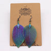 Bravery leaf earrings featuring iridescent purple and green hues with detailed vein pattern on leaf-shaped metal pieces