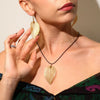 Golden leaf pendant necklace with textured metal finish and black cord, part of a bravery leaf gift set