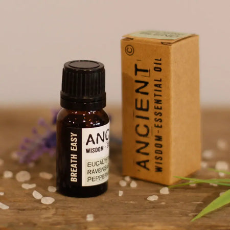 A small amber glass bottle with black cap and white label containing breathe easy essential oil blend 10ml