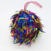 A bright multi-coloured sequinned bauble with spiked sequins and a small diameter hanging by a red ribbon loop