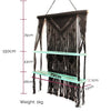 Black macrame hanging shelves with two mint green wooden shelves and hanging fringe in a brown macrame hanging design