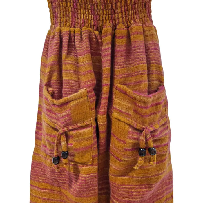 A vibrant ali baba skirt in warm orange and magenta stripes with textured fabric and front pockets tied with beads