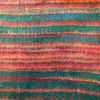 A cozy handwoven scarf with vibrant teal red and orange stripes paired with brushed cashmelon ali baba trousers