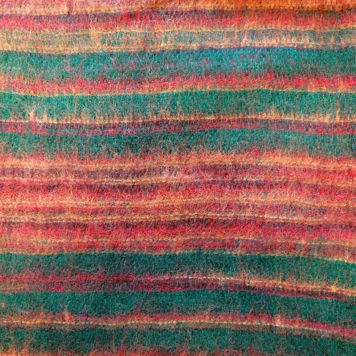 A cozy handwoven scarf with vibrant teal red and orange stripes paired with brushed cashmelon ali baba trousers