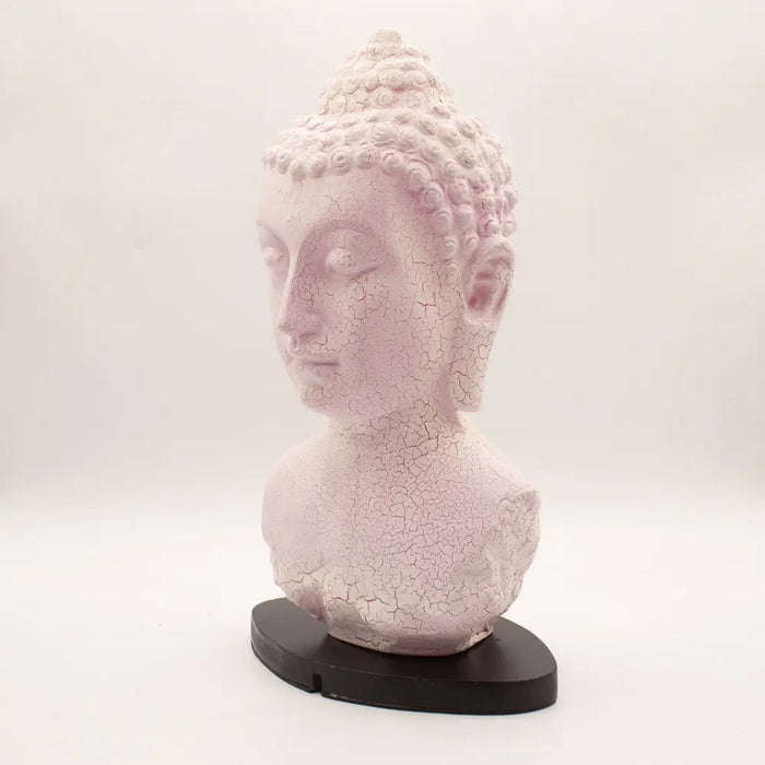 A delicate pink buddha glow lamp bust with cherry crackle finish on a sleek black base