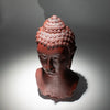 Red terracotta buddha glow lamp bust with detailed curls and molton lava crackle finish showing a serene face