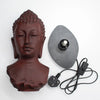 Buddha glow lamp bust with a molton lava crackle textured reddish brown finish on an oval black base