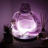 Purple crackle glass laughing buddha lamp with glowing lavender crackle interior light on a dark background