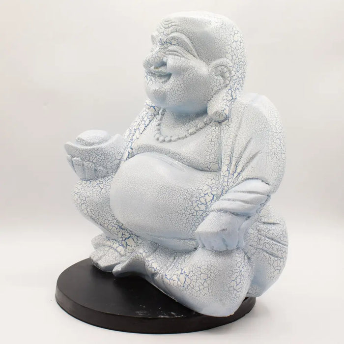 A white resin laughing buddha statue with cracked surface in a seated pose with sky blue crackle finish