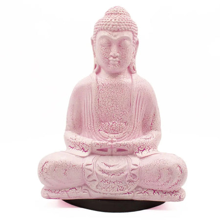 Pink cracked resin buddha statue with cherry crackle effect in meditative pose on a black circular base lamp