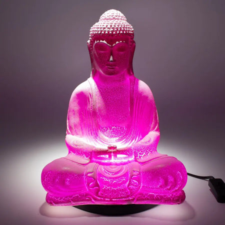 A translucent pink buddha glow lamp with cherry crackle glass finish and glowing internal lighting for meditation
