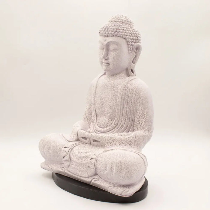 White cracked-finish buddha statue in seated meditation pose on dark base with lavender crackle glow lamp effect