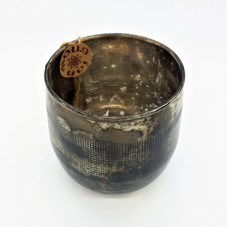 Burnished smoked glass votive candle holder in etched bronze with dark metal grid pattern and rustic patina finish