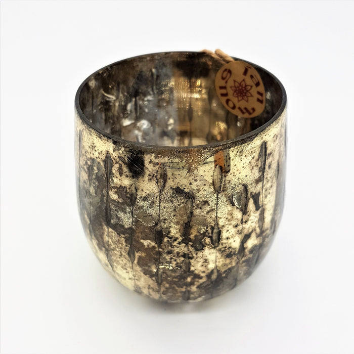 A burnished smoked glass votive candle holder with a textured gold mottled mercury glass finish