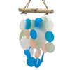 A hanging wind chime made of blue green and white translucent capiz shells and driftwood with a pearl effect
