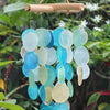 Capiz shells wind chime with blue and pearl effect sea glass discs hanging from a natural bamboo rod