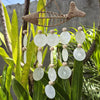 Capiz shell wind chime with handwoven rope, translucent white capiz shells, wooden beads, and raffia fish on five strings