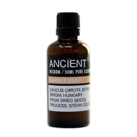 A 50ml amber glass bottle with black ribbed cap labeled ancient wisdom carrot seed essential oil with allergen declarations